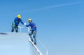 A young technician intern working on solar panels is fear of heights with senior engineers