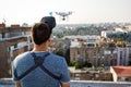 Young technician man flying UAV drone with remote control in city Royalty Free Stock Photo