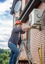 Young technician repairing outside air conditioning unit Royalty Free Stock Photo