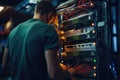 Young technician working on server in datacenter. Selective focus, rear view of An IT Engineer close-up shot of fixing a server
