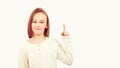 Young teen boy with long hair posing at studio. Guy pointing up at empty space. Boy gesturing new idea Royalty Free Stock Photo