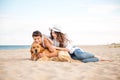 Young teen couple with a dog sitting on the beach Royalty Free Stock Photo