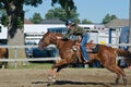 Young teen cowgirl at country fair racing horse