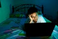 Young Teen in front of a laptop computer and on a bed Royalty Free Stock Photo