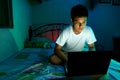 Young Teen in front of a laptop computer and on a bed Royalty Free Stock Photo