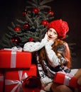 Young teen girl celebrating New year 2020 Xmas and decorates a christmas tree in red winter hat and presents gift boxes Royalty Free Stock Photo