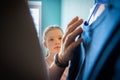 Young teen girl chooses a suitable outfit in the wardrobe in the bedroom at home. Clothes hanging on hangers in the closet