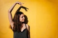 Young teen girl dancing outdoors on yellow wall background in urban area Royalty Free Stock Photo