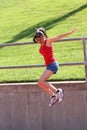 Young teen girl jumping blue shorts red top Royalty Free Stock Photo