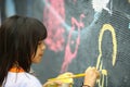 Young teen girl paints the wall