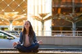 Young girl yoga and meditates in the lotus position in a big city Royalty Free Stock Photo