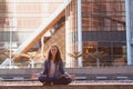 young girl yoga and meditates in the lotus position in a big city Royalty Free Stock Photo