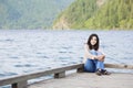 Young teen girl relaxing quietly on lake pier, Royalty Free Stock Photo