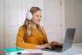 Teen Girl Using Laptop And Headphones at Desk Royalty Free Stock Photo