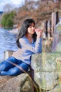 Young teen girl sitting outdoors on rocks praying Royalty Free Stock Photo