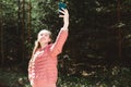 Young teen girl traveler taking selfie on mobile phone in a summer day forest. girl looking at smartphone camera Royalty Free Stock Photo