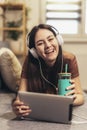 Teen girl using digital tablet computer listening music at home Royalty Free Stock Photo