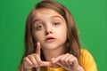 The young teen girl whispering a secret behind her hand over green background