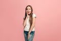 The young teen girl whispering a secret behind her hand over pink background Royalty Free Stock Photo