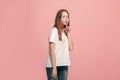 The young teen girl whispering a secret behind her hand over pink background Royalty Free Stock Photo