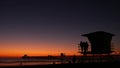 Young teen girls silhouettes, lifeguard watch tower, friends on pacific ocean beach, California USA.