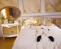 Young teen guy wearing white business suit and lying on the bed in his Golden room, stretching and yawning