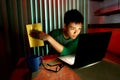 Young Teen holding a book in front of a laptop computer