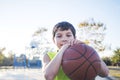 Portrait of a young teen male with sleeveless standing on a street basket court while smiling at camera