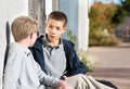 Young teen males talking to friend outside