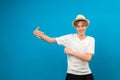 Young teen man points palms aside isolated on blue. Friendly well-looking boy paying your attention at copy space, best deal, sale Royalty Free Stock Photo