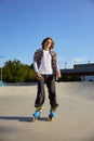 Young teen in rollerblades making stunt on cement ramp in skate park Royalty Free Stock Photo