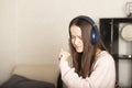 Young teen student girl listening to music at home with headphones, dancing, singing along Royalty Free Stock Photo