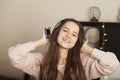 Young teen student girl listening to music at home with headphones, smiling Royalty Free Stock Photo
