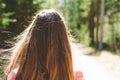 Young teen woman walking on a trail in a summer sunny day forest.The girl`s hair is long. She relaxes in the fresh air Royalty Free Stock Photo