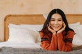 Young teenage Asian woman wears a sweater with pretty smile looking at camera in bedroom. Attractive girl with facial Royalty Free Stock Photo