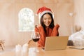 Young teenage Asian woman wears sweater with pretty smile and santa hat in bedroom. Happy and successful girl using Royalty Free Stock Photo