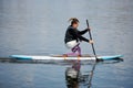 Young teenage boy with disability paddleboarding on lake