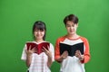 Young teenage boy and girl standing and reading at book at green Royalty Free Stock Photo