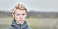 A young teenage boy looking sad and thoughtful while standing alone in a public park. Lonely child feels bad because he Royalty Free Stock Photo