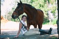 Young teenage cheerful girl equestrian hugging her favorite chestnut horse