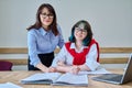 Young teenage female studying languages with teacher in classroom