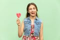 Young teenage girl with blondie long hair, wink at camera, tongue out, holds lolipop, having funny look.