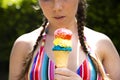 Young teenage girl eating icecream cone wearing pink sunglasses and braids on hot summer Royalty Free Stock Photo