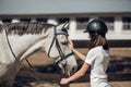 Young teenage girl equestrian showing love and care to her favorite horse. Dressage outfit