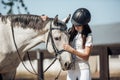 Young teenage girl equestrian showing love and care to her favorite horse. Dressage outfit