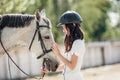 Young teenage girl equestrian showing love and care to her favorite horse. Dressage outfit