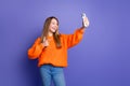 Young teenage girl gesture finger symbol photo subscribers are cool takes selfie shot using smartphone isolated on Royalty Free Stock Photo