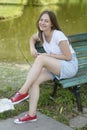 Young teenage girl having fun in the park, on a bench. Education, school girl. Smiling young woman. Summer holidays Royalty Free Stock Photo