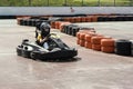 A young teenage girl in a helmet is racing on a high-speed go-kart on a racing track. Karting is a popular form of active recreati Royalty Free Stock Photo