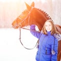 Young teenage girl with her horse in winter park Royalty Free Stock Photo